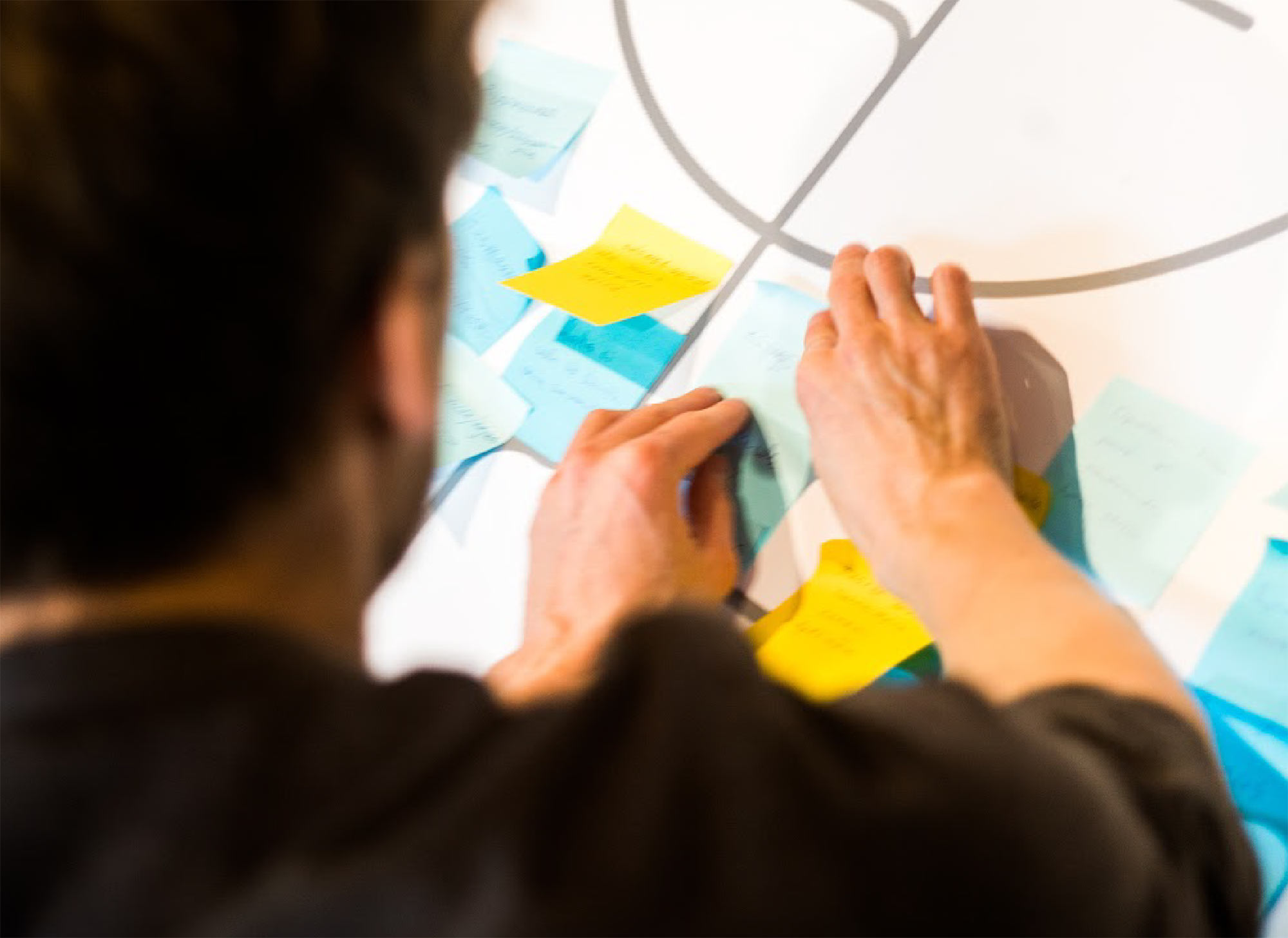 Participant places sticky notes on a table at a workshop